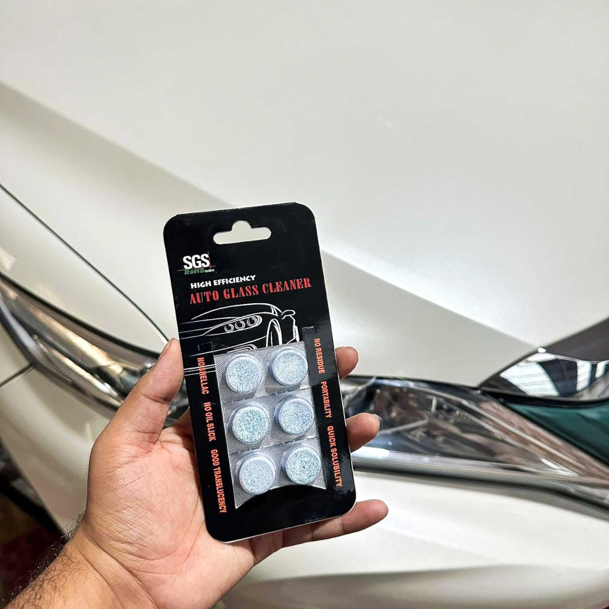 sgs auto glass cleaner tablet in hand using on a toyota harrier